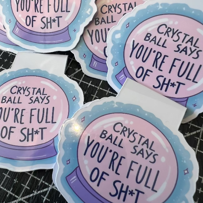 Stickers with a crystal ball design and text on a black grid background
