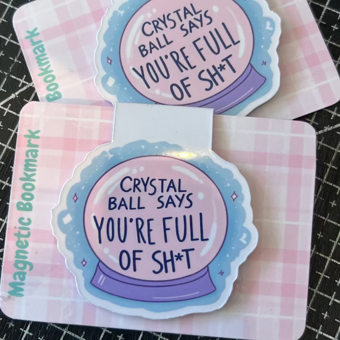 Two magnetic bookmarks with crystal ball design and text on a checkered background