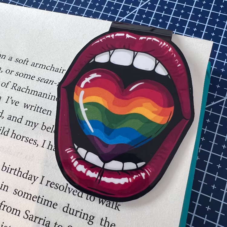 LGBTQ+ pride-themed bookmark with rainbow heart design on a book page.