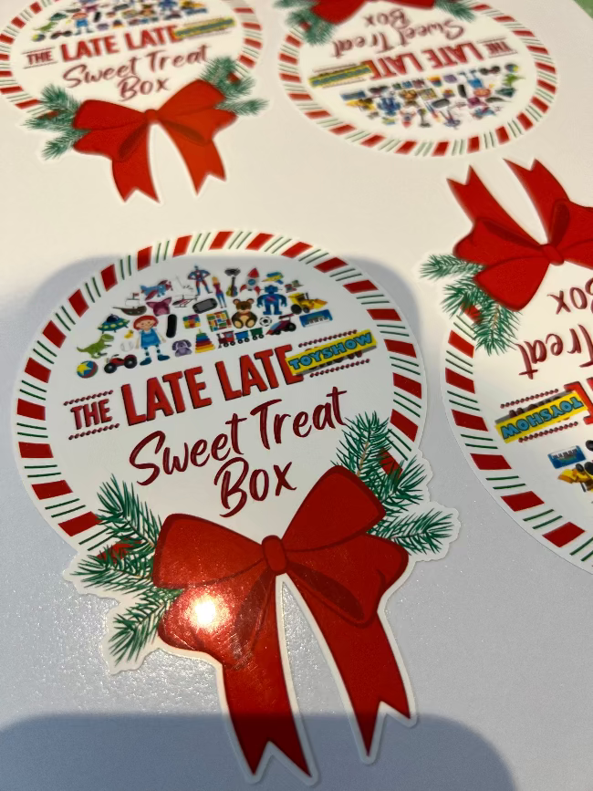 Decorative packaging for 'The Late Late Sweet Treat Box' with a red bow and festive design.