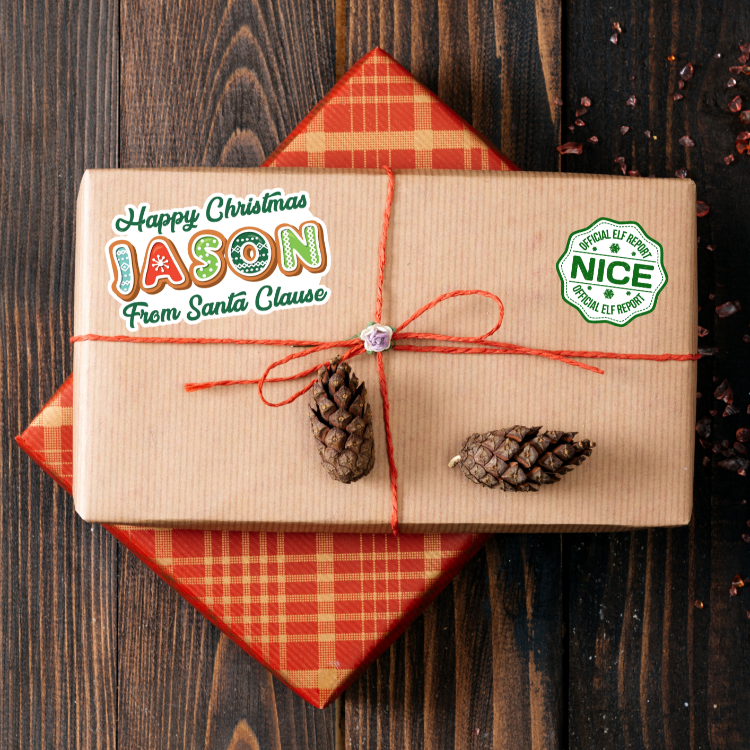 Gift box with 'Happy Christmas Jason from Santa Clause' label and pinecones on a wooden background