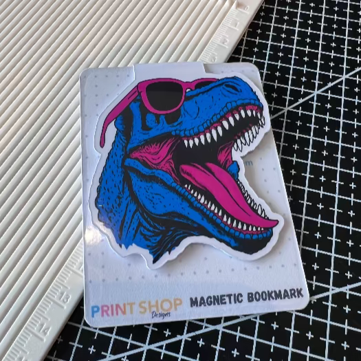 Magnetic bookmark with a dinosaur design on a cutting mat