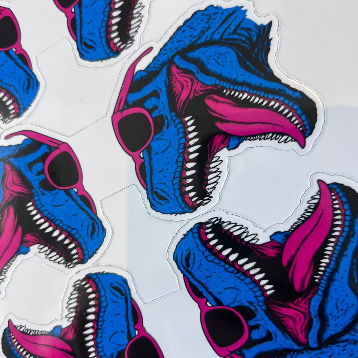 Sticker design of a blue and pink creature with open mouth on a white background