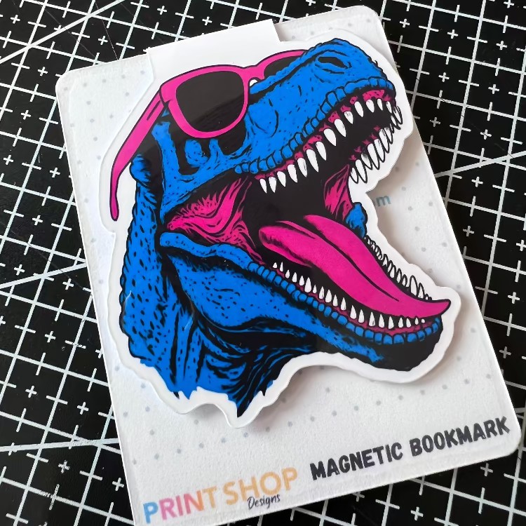 Magnetic bookmark with a colorful dinosaur design on a grid background