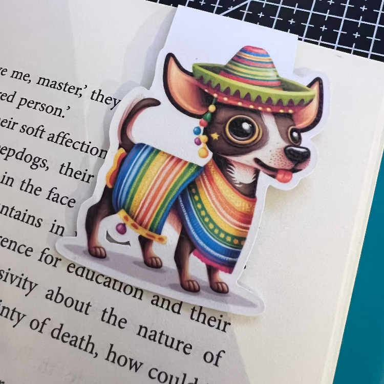 Magnet of a dog wearing a colorful poncho and sombrero on a book page.