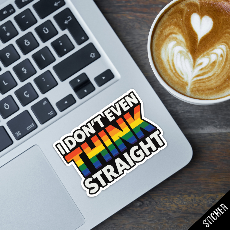 Laptop with a rainbow sticker on a wooden surface next to a cup of coffee.