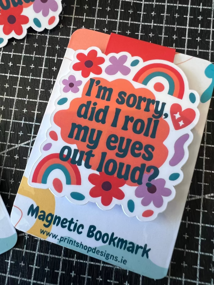 Magnetic bookmark with colorful design and text on a black grid background