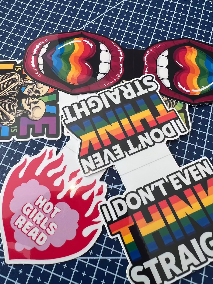 Collection of colorful stickers with text and designs on a grid background