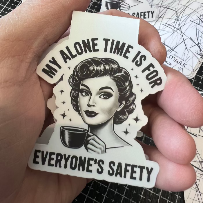 Magnet Bookmark with a vintage-style illustration of a woman holding a coffee cup and text, held by a hand on a grid background.