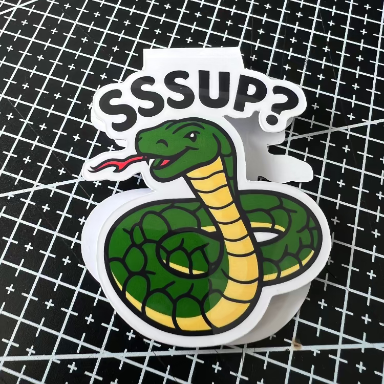 Sticker of a snake with a speech bubble saying 'SSSUP?' on a grid background