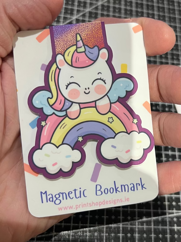 Magnetic bookmark with a unicorn design held by a hand